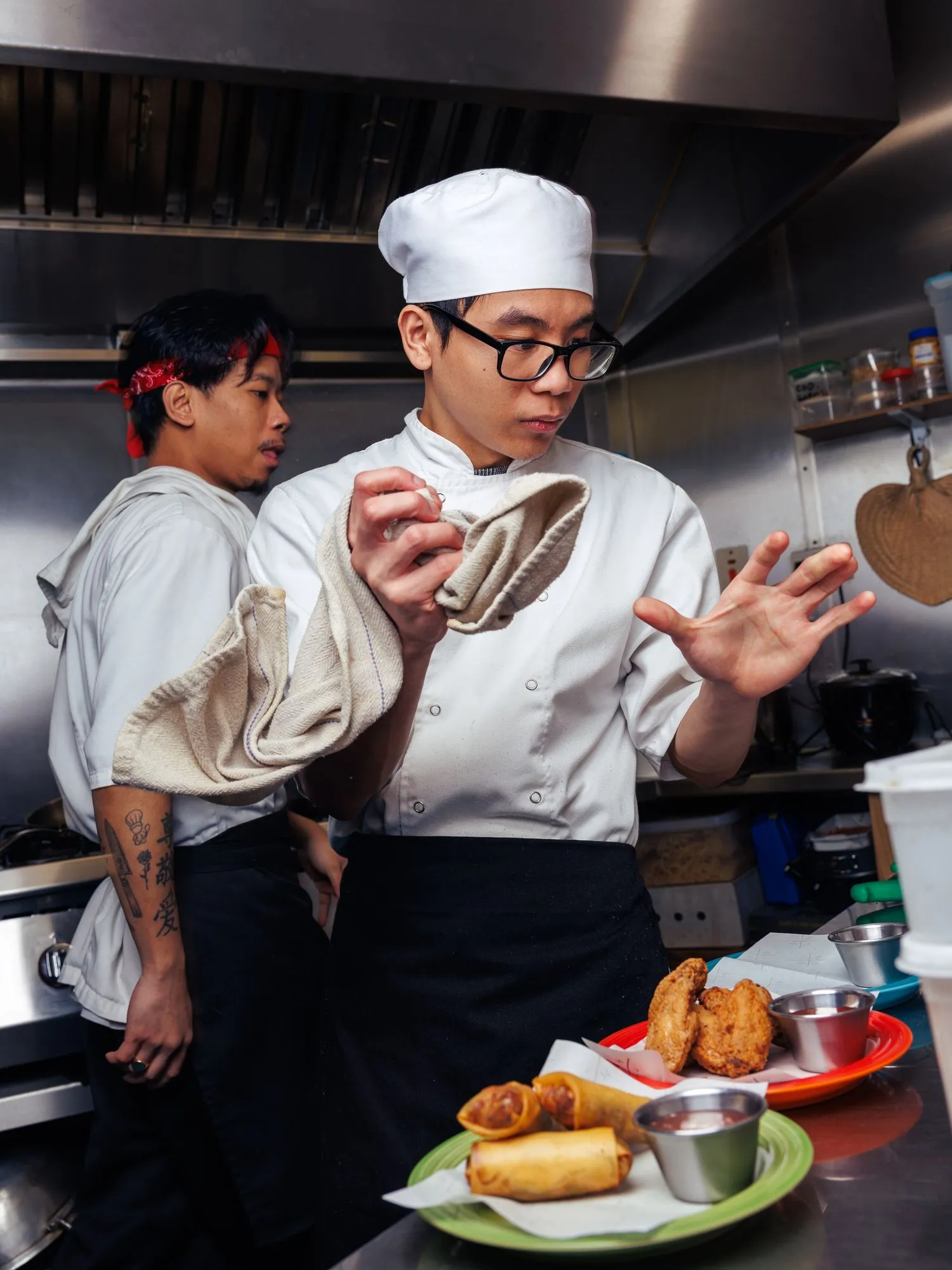Two chefs plating food in the Mina's Table kitchen.