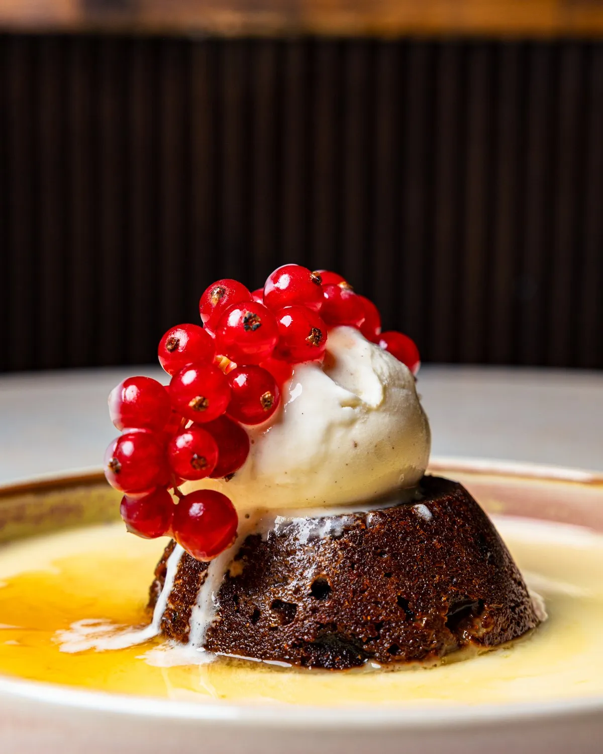 Sticky toffee pudding with vanilla ice cream and redcurrants in custard at Pemberleys.